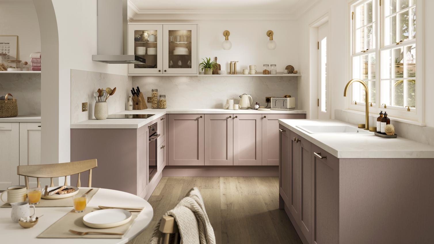 A pink kitchen idea with antique-rose cupboards in a shaker design. Has white wall units and worktops, plus open shelving.