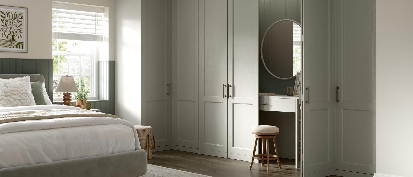 Bedroom with shaker-style fronts in a light pebble colour. Behind one door is a dresser unit with matching door and mirror.