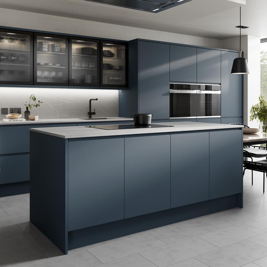 Contemporary marine blue kitchen in an island layout with a matt finish. Includes a grey worktop and black glass wall units.